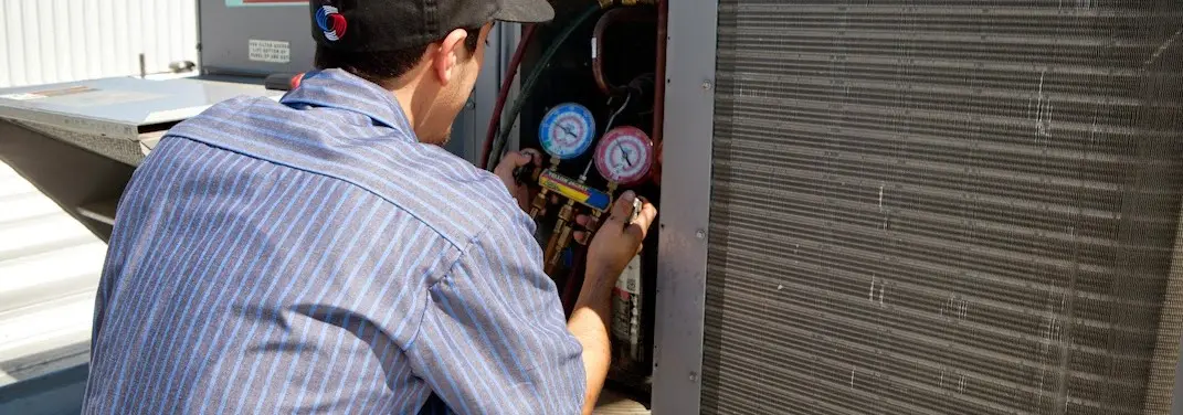 HVAC technician servicing a condenser unit in Opa-locka